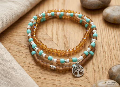 Three glass bead bracelets in amber, turquoise and brown tones with silver-tone details and a tree charm