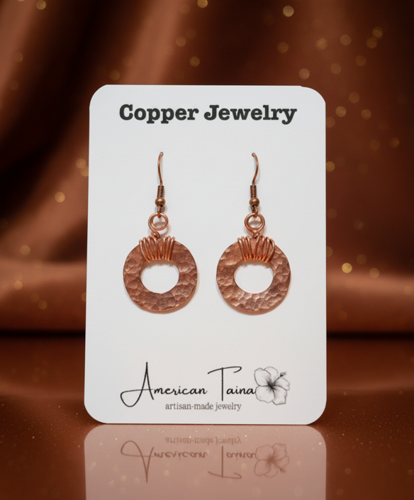 Hammered copper hoop earrings with wire-wrapped detail on American Taina jewelry card