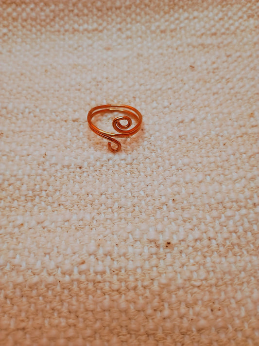 Handmade copper wire spiral ring held showing detail