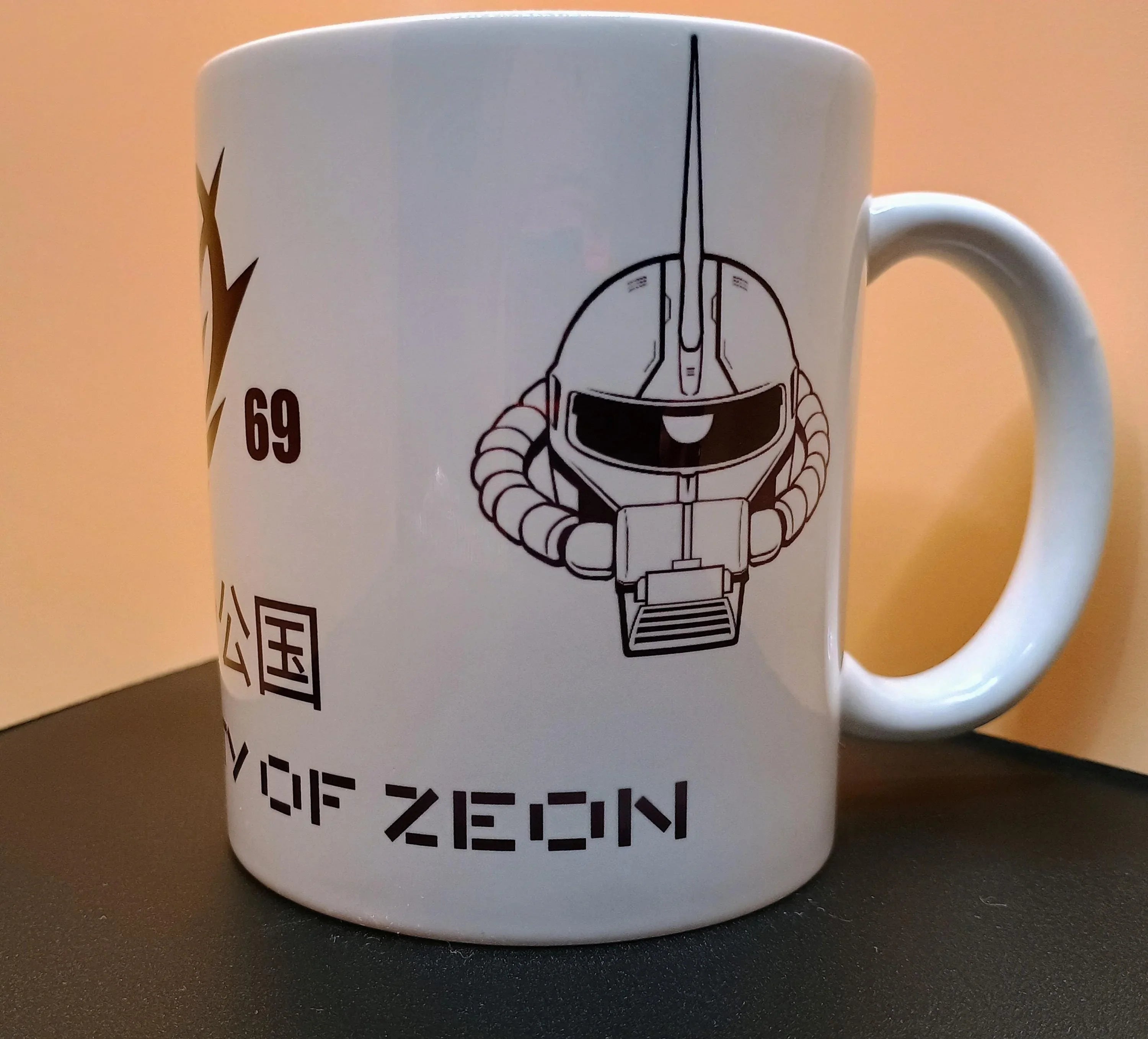 White ceramic mug with black and white anime robot helmet design and text 'CITY OF ZEON'
