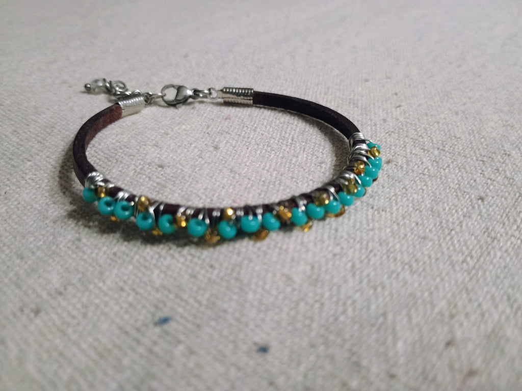 Bracelet with turquoise and gold beads on a gray background