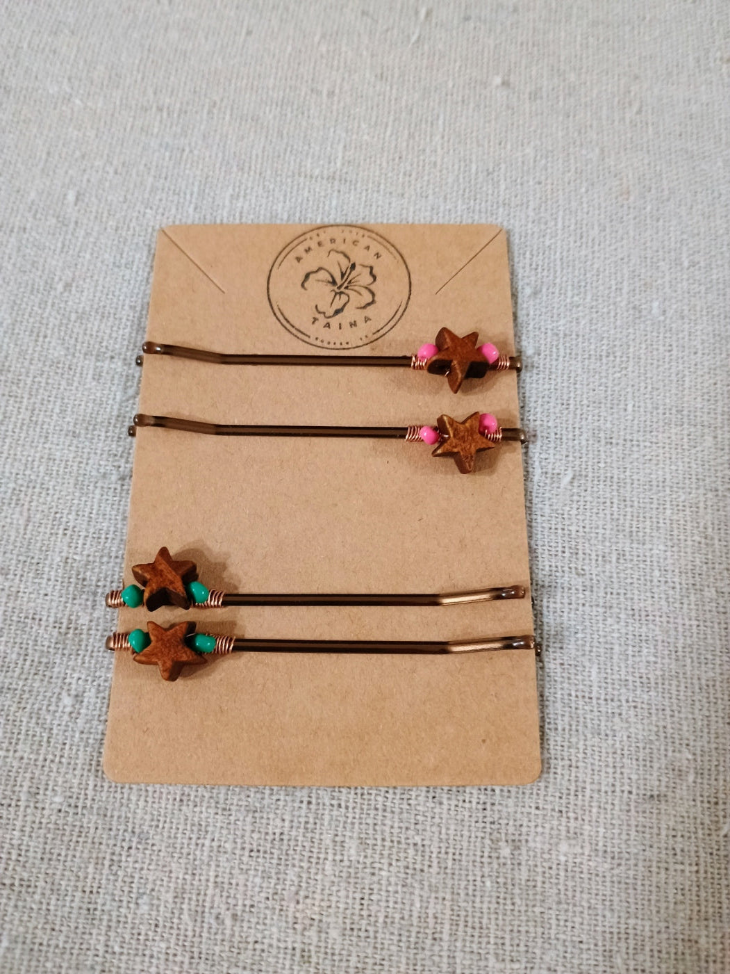 Pair of hair ties with star-shaped ends on a cardboard backing with a brand logo.