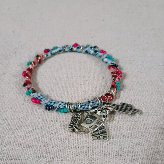 Multicolored beaded bracelet with charms on a textured surface