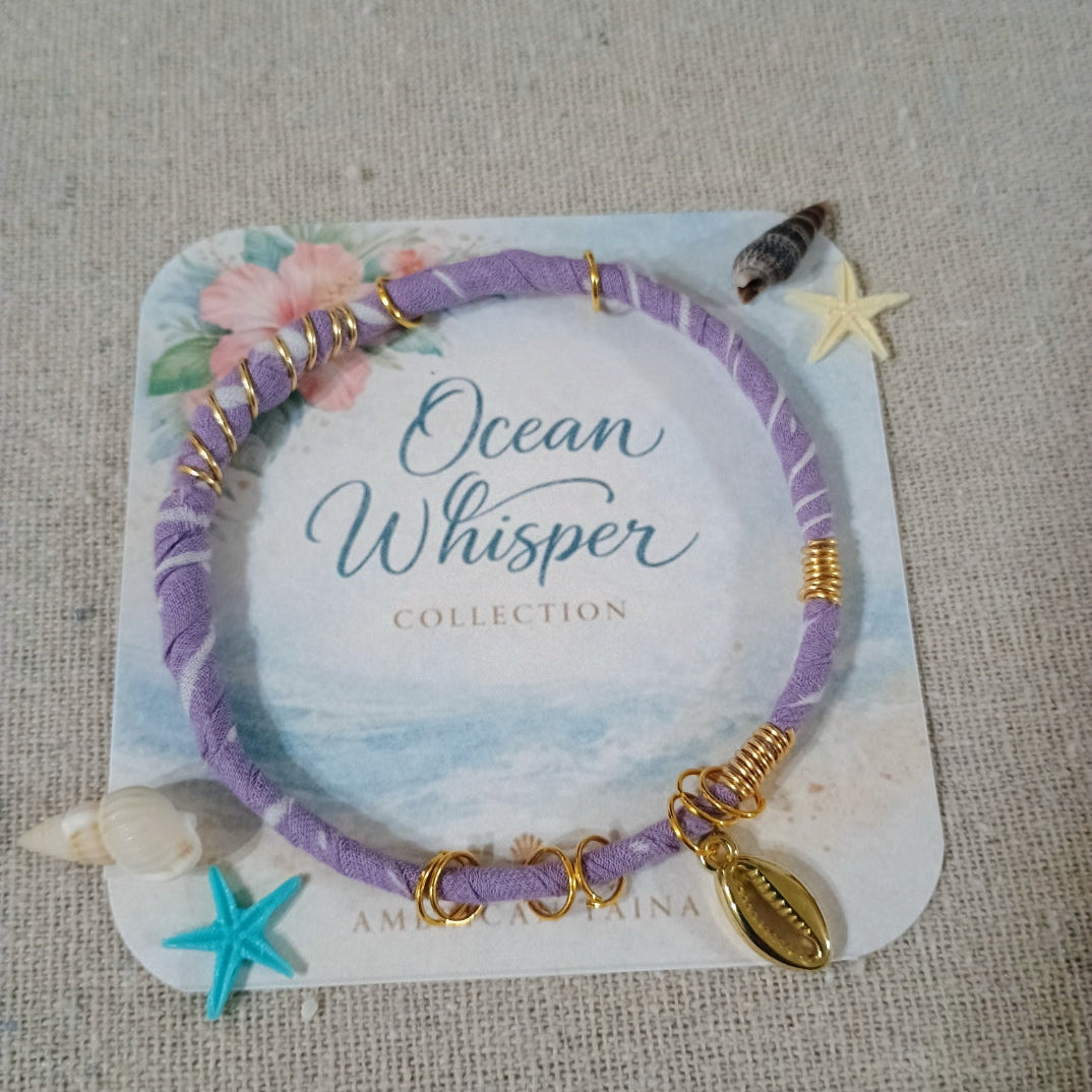 Purple bracelet with gold accents on a 'Ocean Whisper' collection card, displayed on a textured surface.