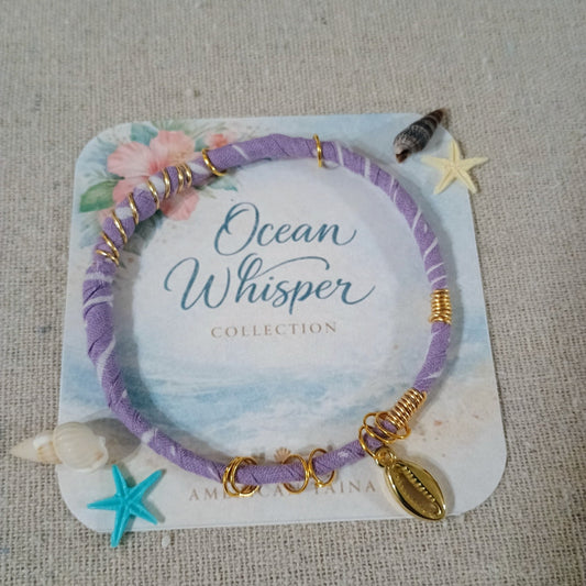 Purple bracelet with gold accents on a 'Ocean Whisper' collection card, displayed on a textured surface.