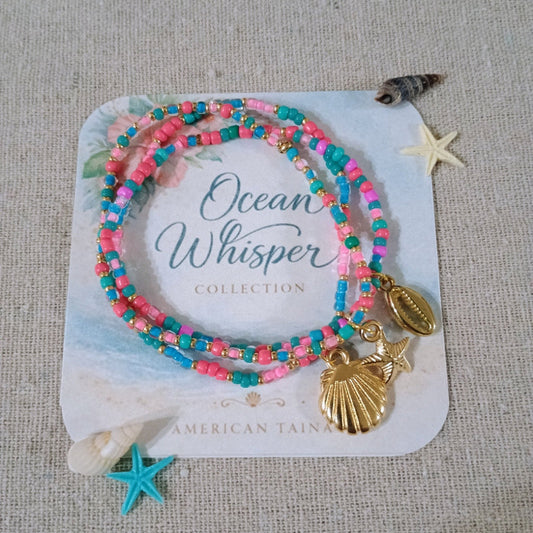 Set of colorful beaded bracelets with shell charms on a branded card.