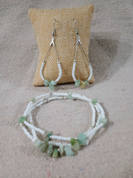 Beaded necklace and earrings on a textured surface with a burlap pillow.