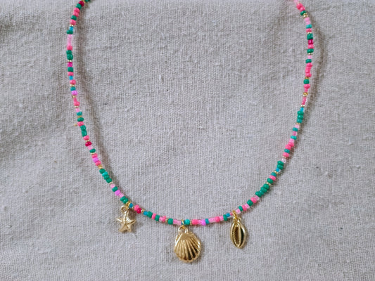 Necklace with colorful beads and gold shell charms on a gray background