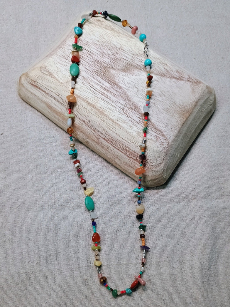 Beaded necklace on a wooden block with a neutral background