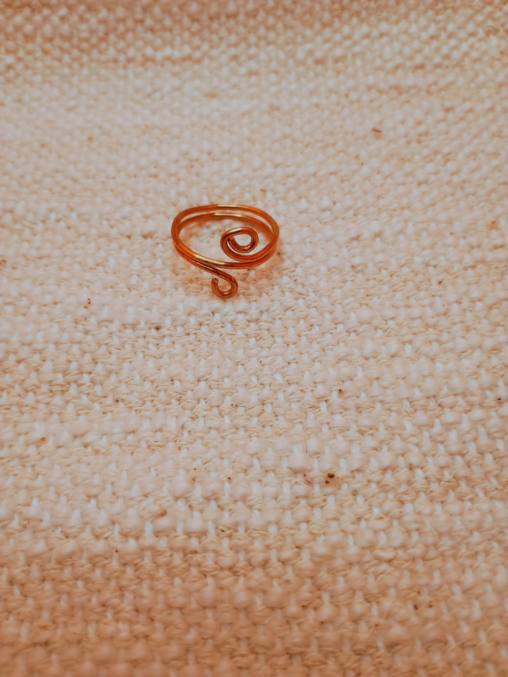 Handmade copper wire spiral ring held showing detail