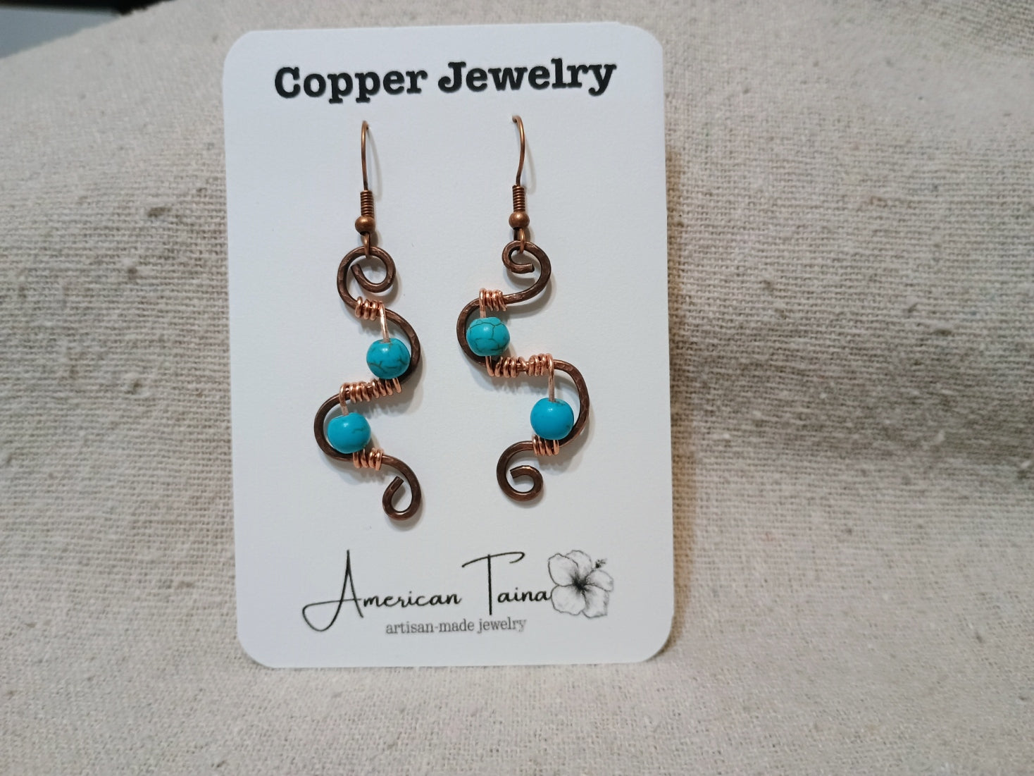 Copper S-curve earrings with wire-wrapped turquoise beads on American Taina jewelry card