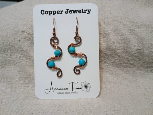 Copper S-curve earrings with wire-wrapped turquoise beads on American Taina jewelry card