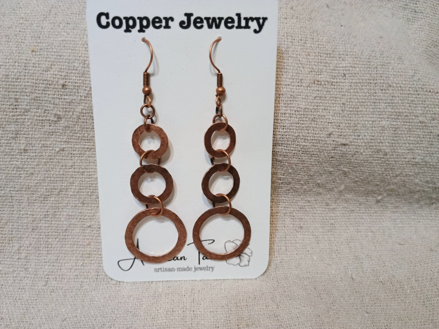 Copper triple ring dangle earrings on American Taina jewelry card
