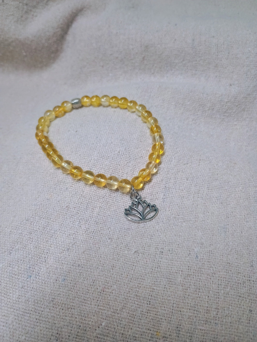 Golden yellow beaded bracelet with silver-tone lotus flower charm