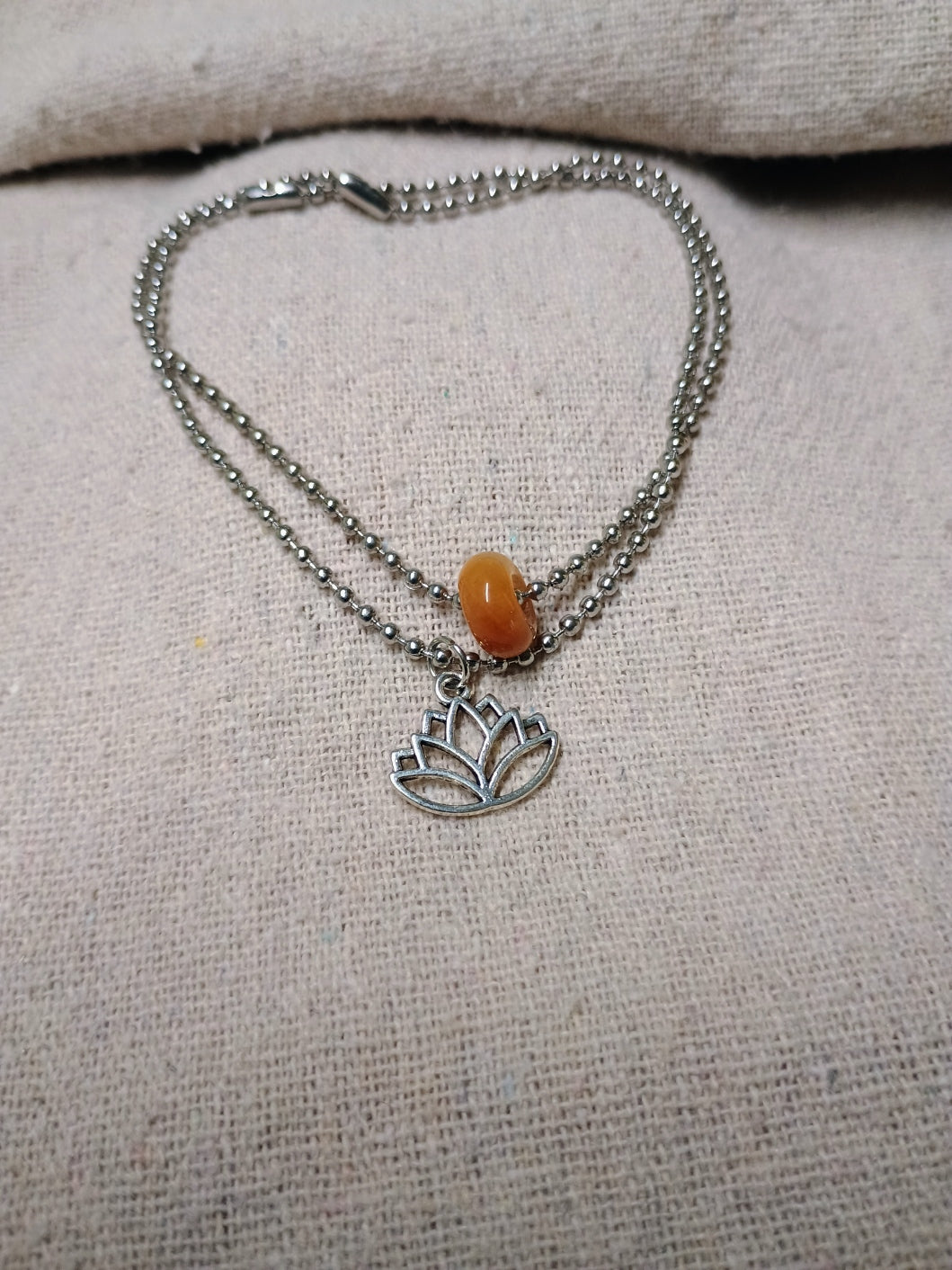 Silver-tone ball-chain bracelet set with an amber-colored natural stone bead and lotus charm
