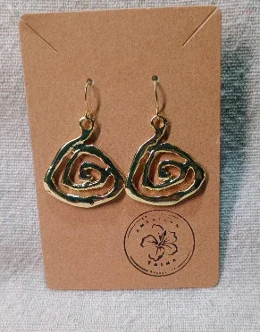 Gold spiral drop earrings displayed on brown card with floral logo on fabric background