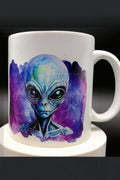 White ceramic mug with detailed blue alien face illustration and purple galaxy background