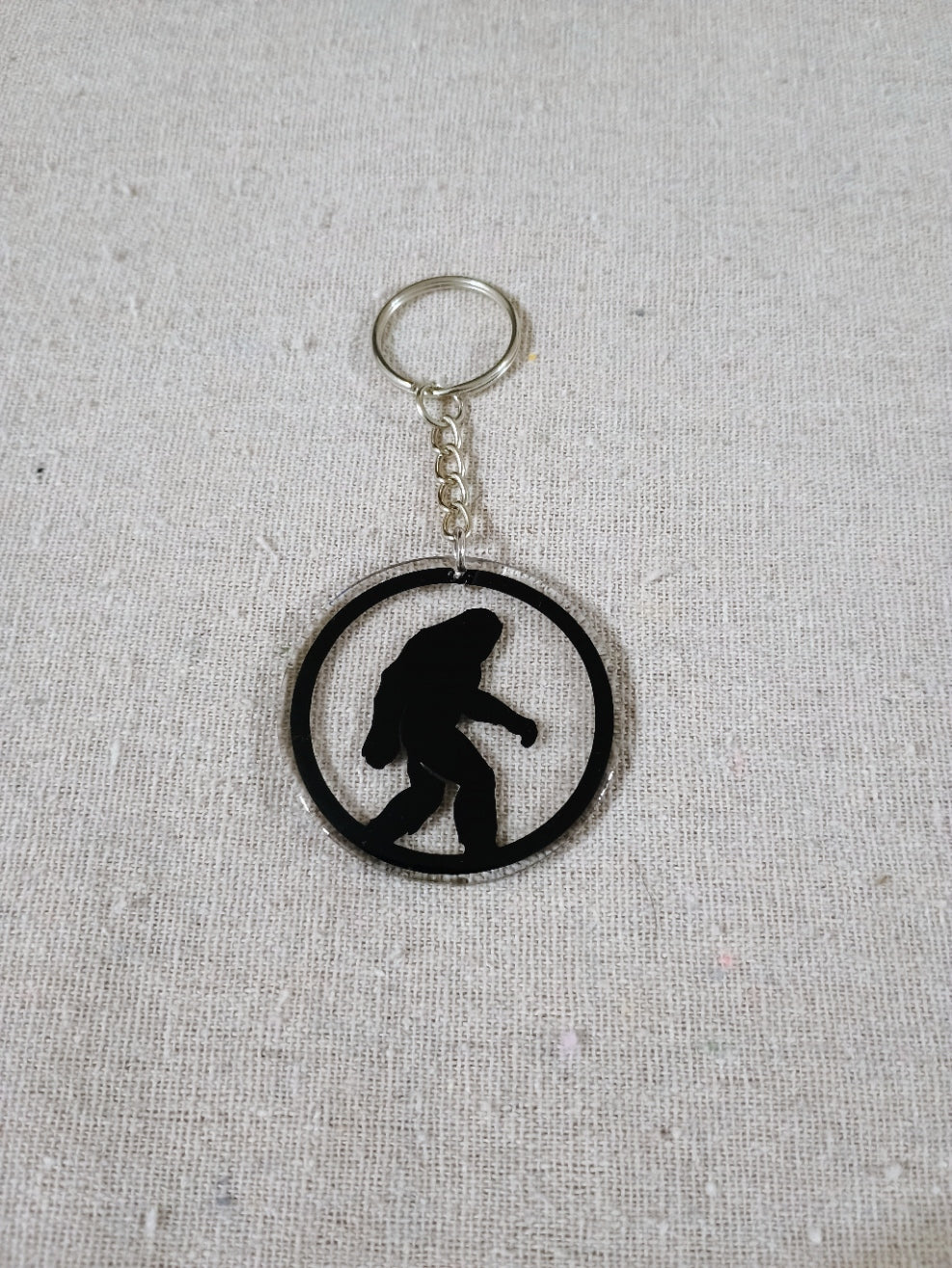 Keychain with a silhouette of a person in a circle on a gray fabric background