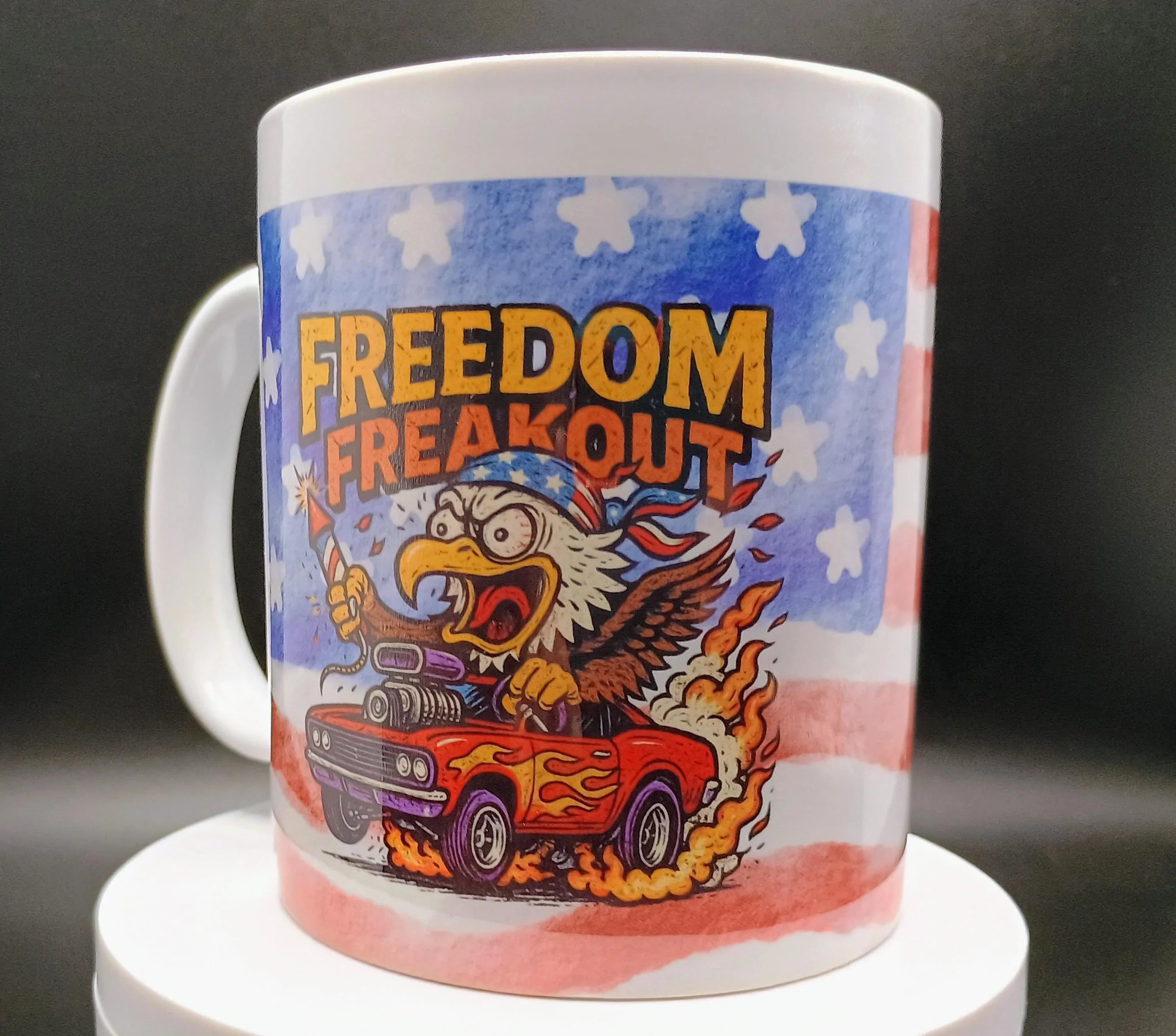 White mug featuring aggressive eagle in American flag bandana driving flaming red car with text Freedom Freakout