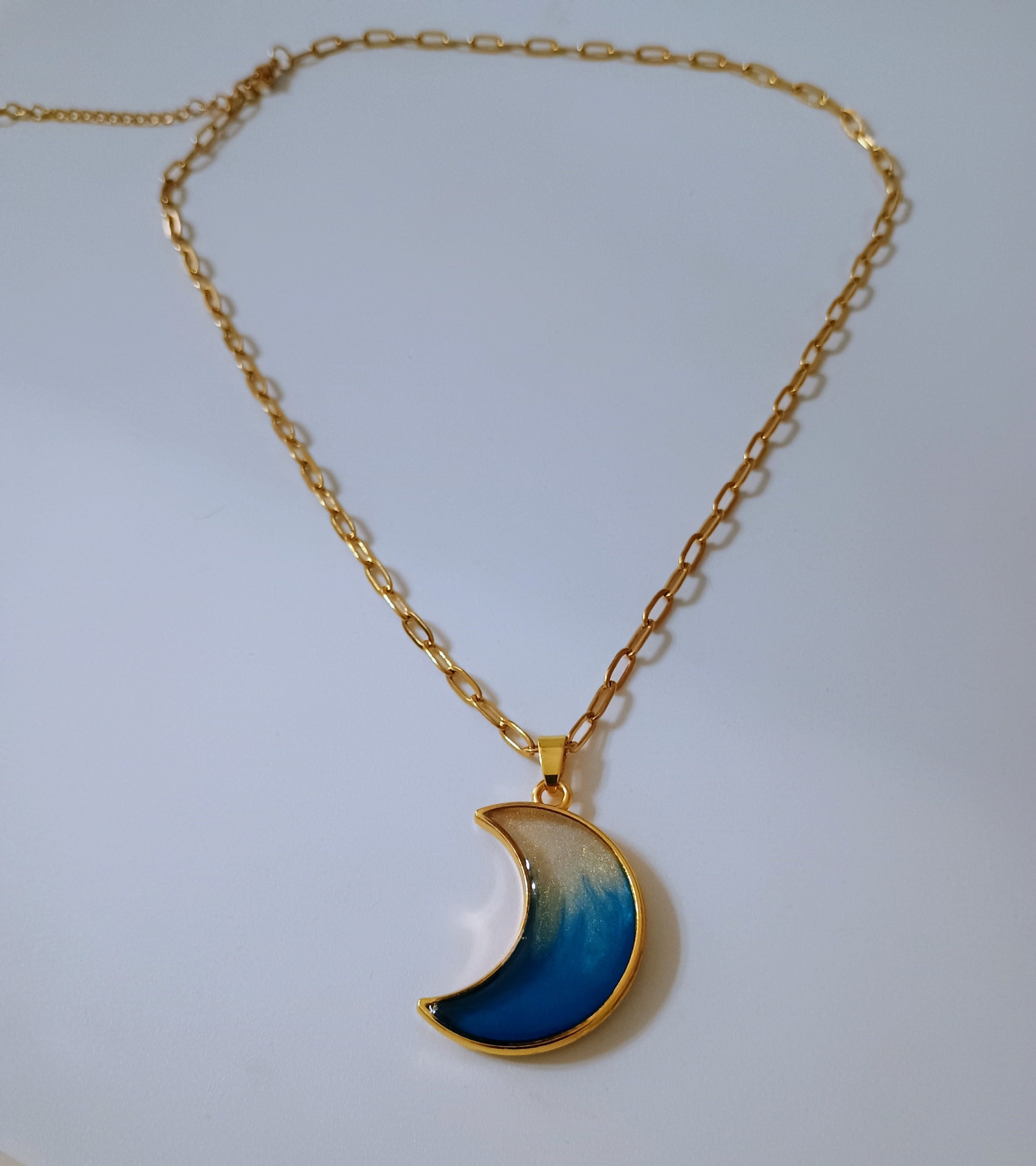 Gold necklace with a blue crescent moon pendant 