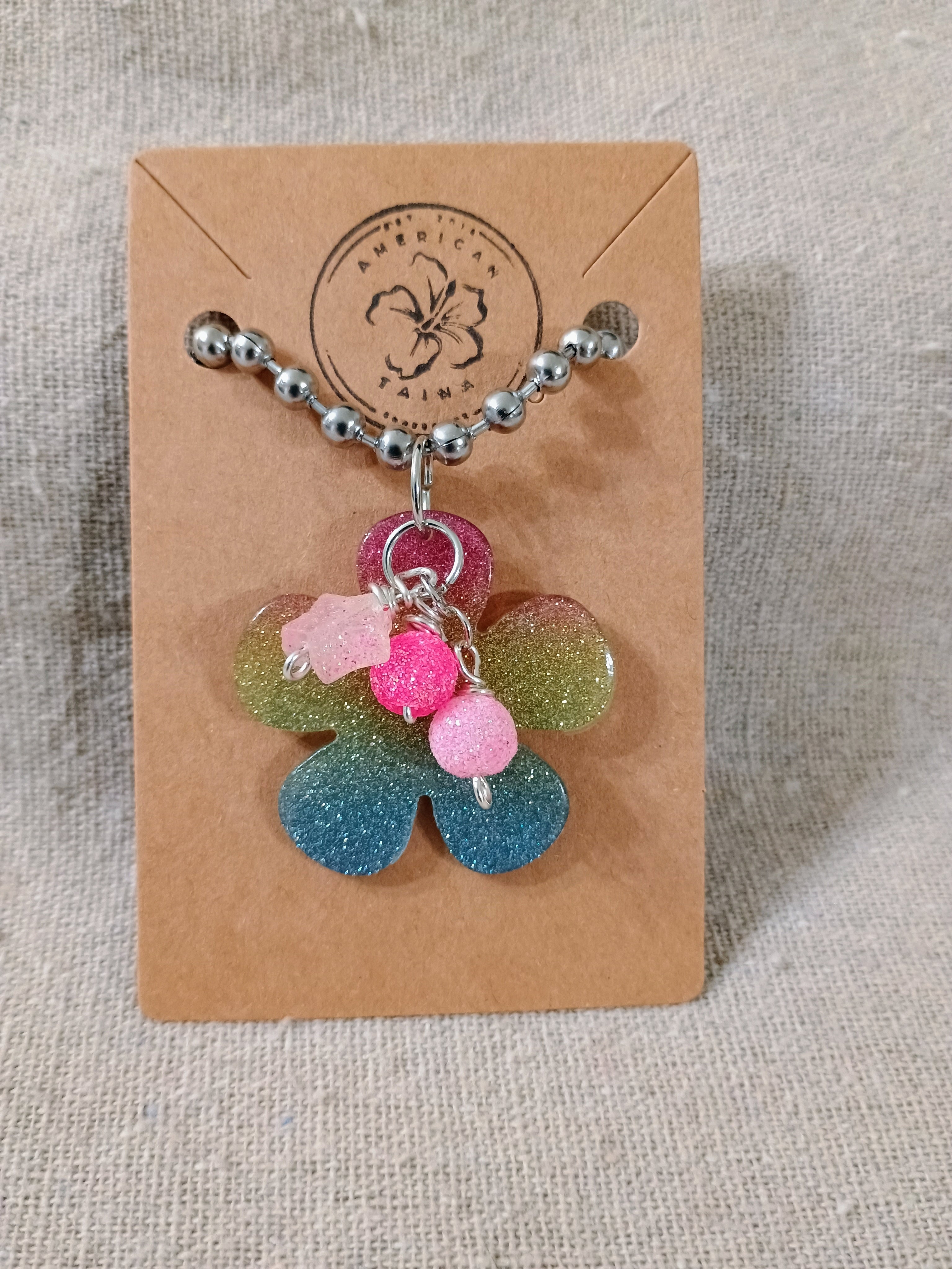 Handcrafted glittery flower keychain with pink bead charms on silver ball chain, displayed on brown American Taina card