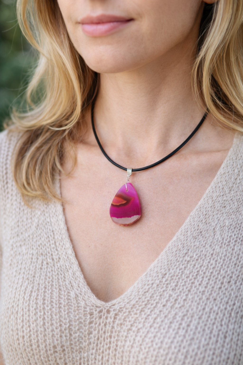 Necklace with a pink pendant worn by a person